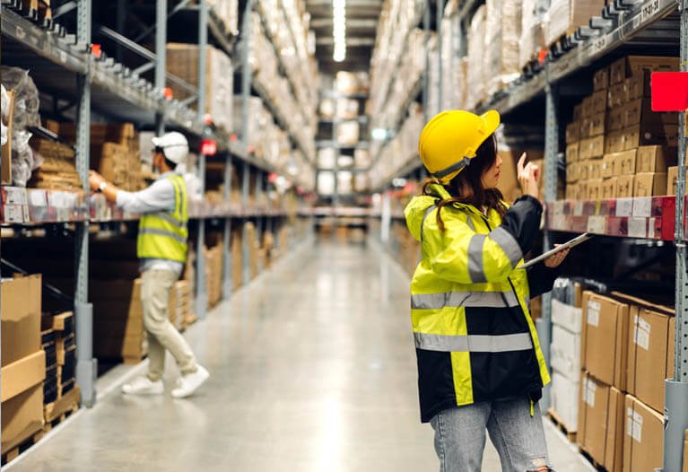 Shipping dock worker in hi-vis jacket loading cargo containers