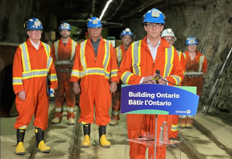 Underground mining workers wearing high-visibility safety clothing in tunnel operations
