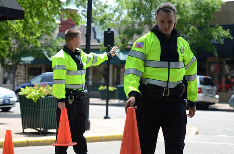 A road worker in a hi-vis hoodie managing traffic, an example of a variable work environment.