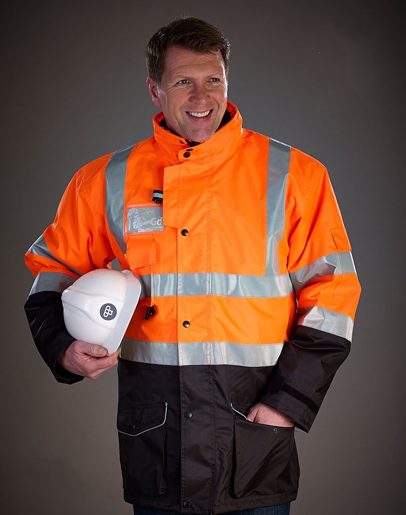 Group of workers wearing various styles of high-visibility rain jackets in outdoor work environment