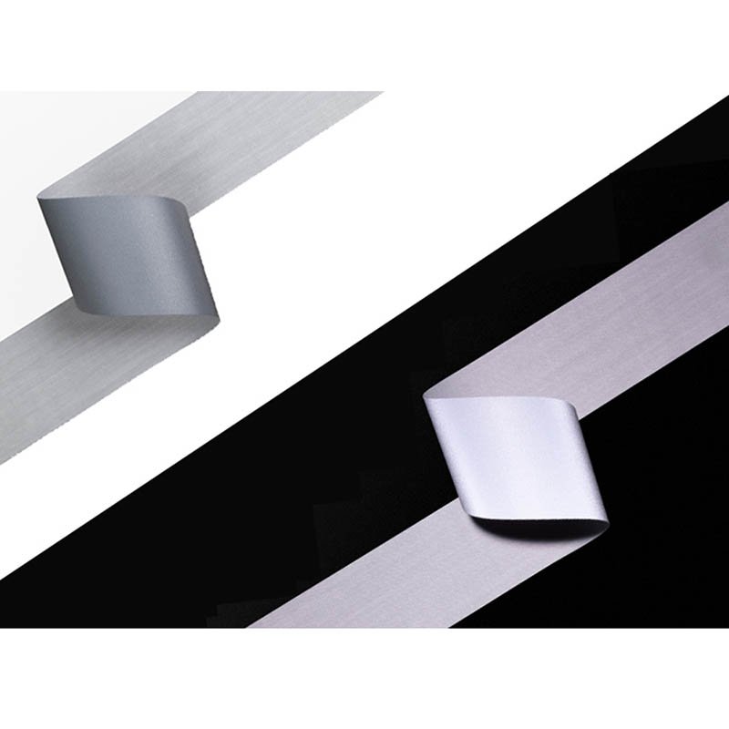 Close-up of a segmented reflective tape on a hi-vis garment, showing its texture and detail.