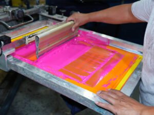 Professional screen printing process showing vibrant logo application